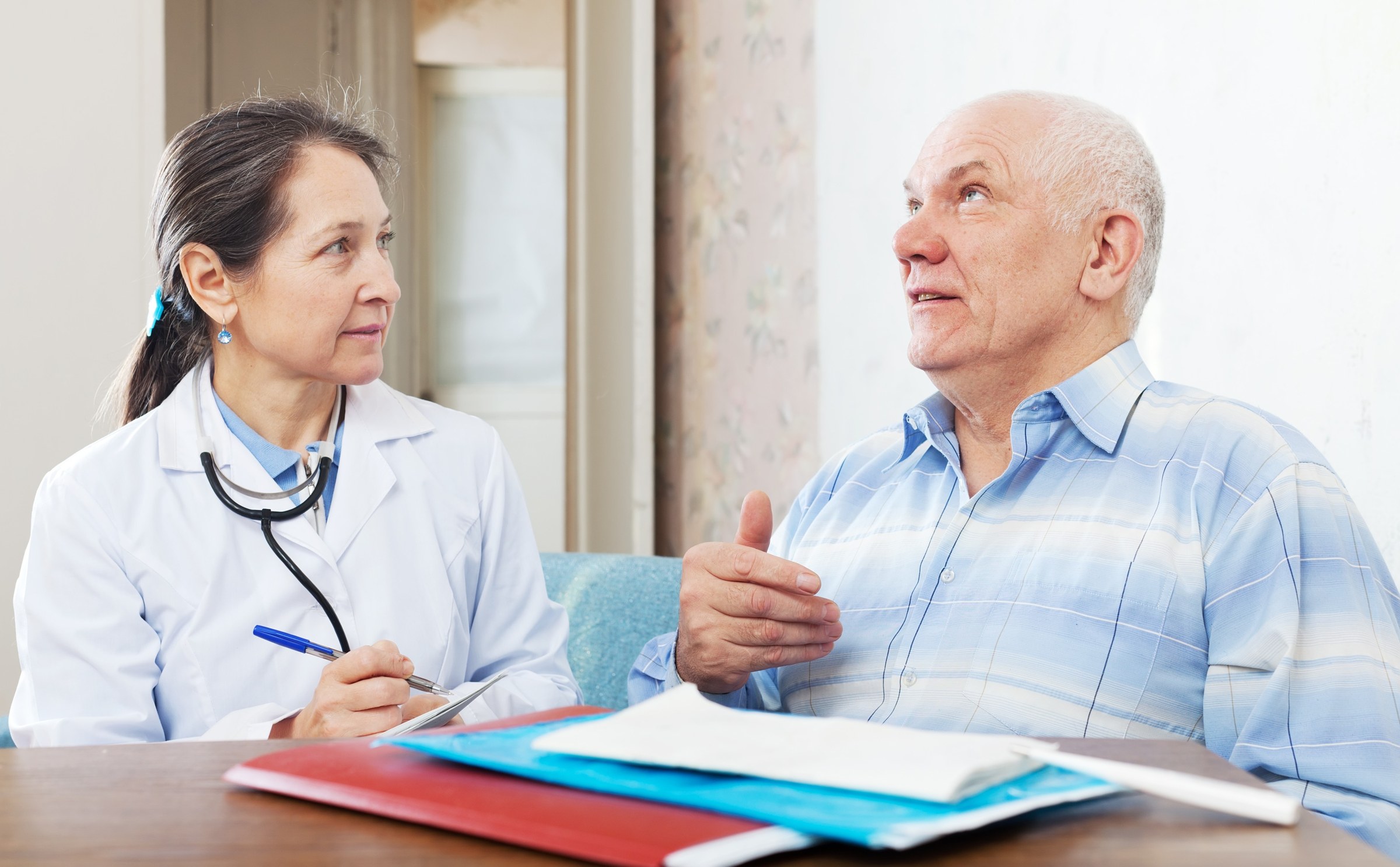 Professionnel médico-social remplissant la grille AGGIR lors d'une évaluation d'autonomie au domicile d'une personne âgée